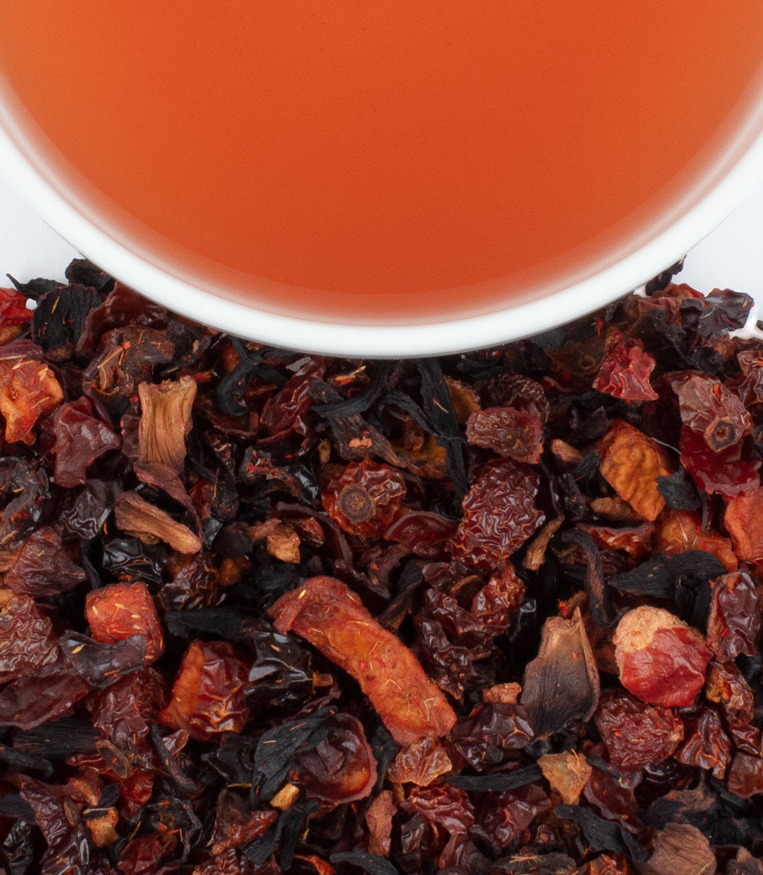 Peach fruit tea sachets with dried fruit blend and brewed tea in a cup, perfect for refreshing beverages.