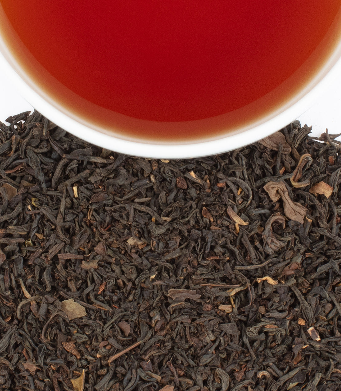Botanical Blend Earl Grey tea sachets with brewed tea in a cup, showcasing rich black tea leaves.