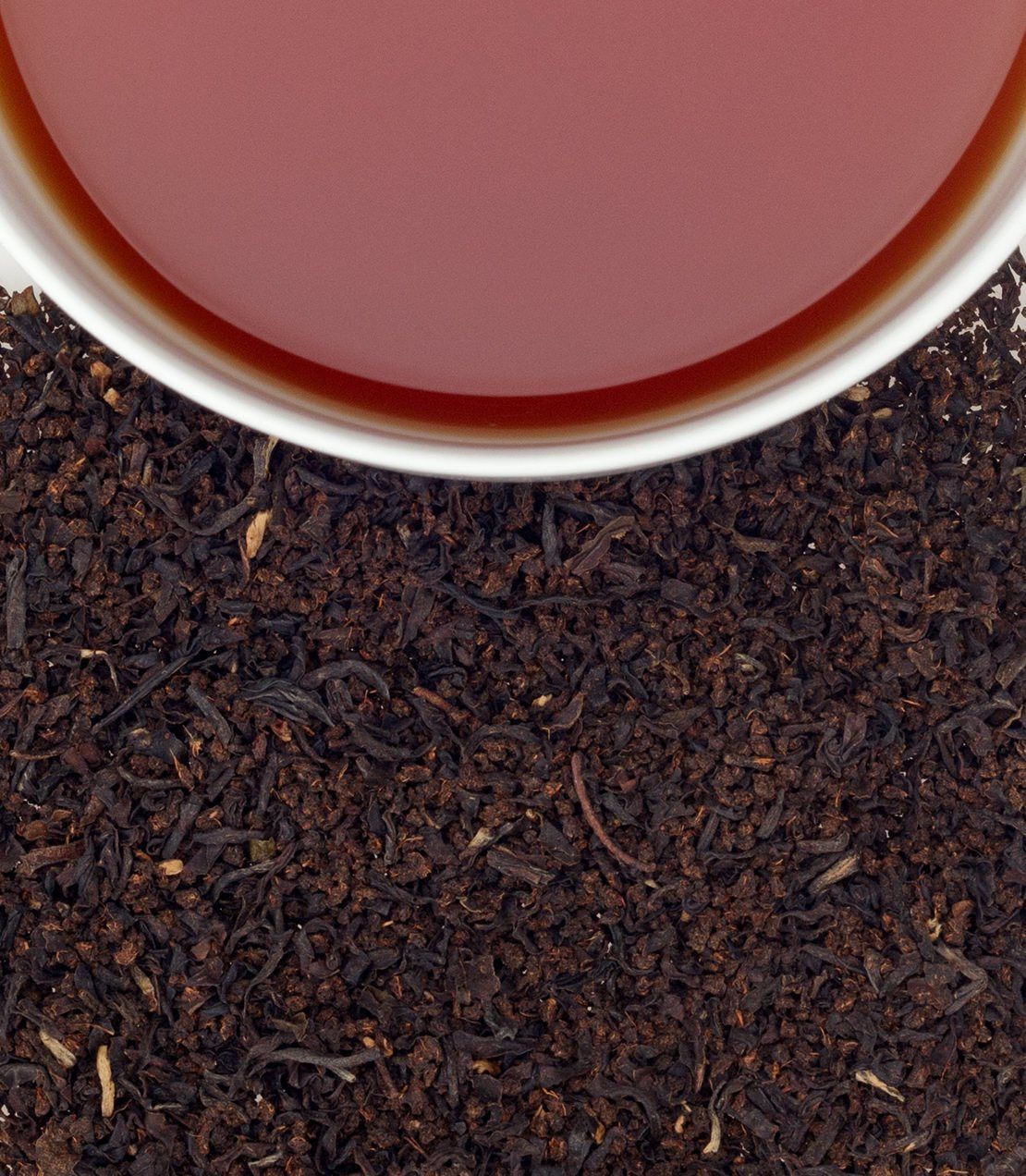 AOH Hibernian Blend tea sachets with brewed tea in a cup and loose tea leaves below. Perfect for a cozy brew.