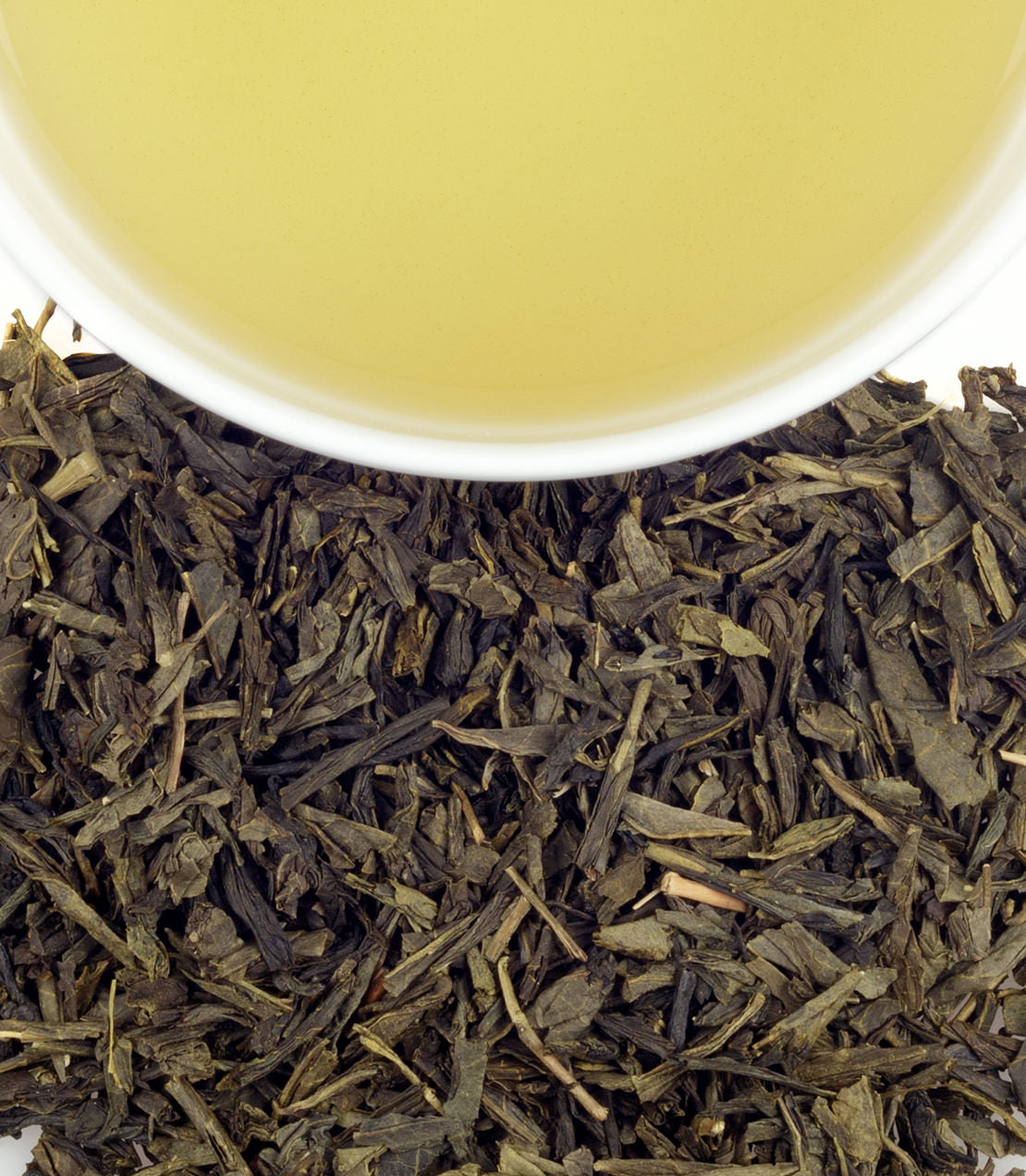 Tropical Green tea sachets in a tin, with brewed tea and loose leaves displayed above.