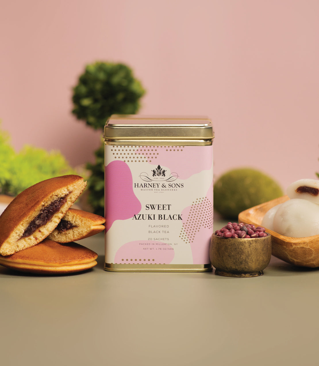 Tin of 20 Sweet Azuki Black tea sachets by Harney & Sons, featuring a pink design and surrounded by treats.